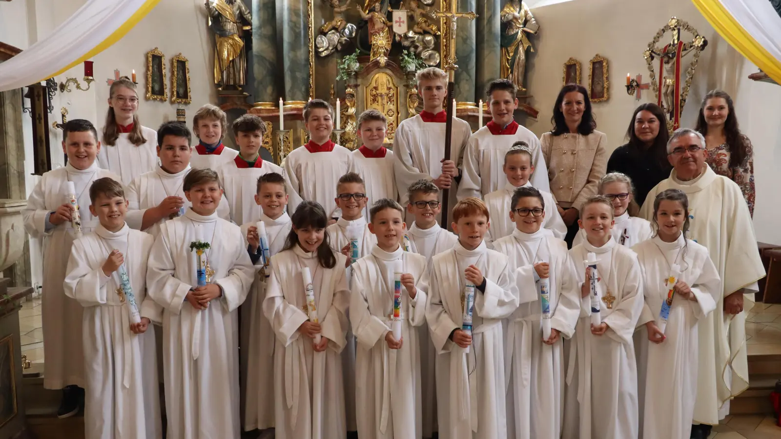Die 15 Erstkommunionkinder aus Vilshofen und Rieden, in der oberen Reihe die Ministranten mit Schulrektorin Christine Kölbl (ab 3.v.r), den Lehrerinnen Anna Liebhäuser und Viktoria Steindl sowie davor Pfarrer Slawomir Niemczewski (Bild: Michael Rabenhofer)