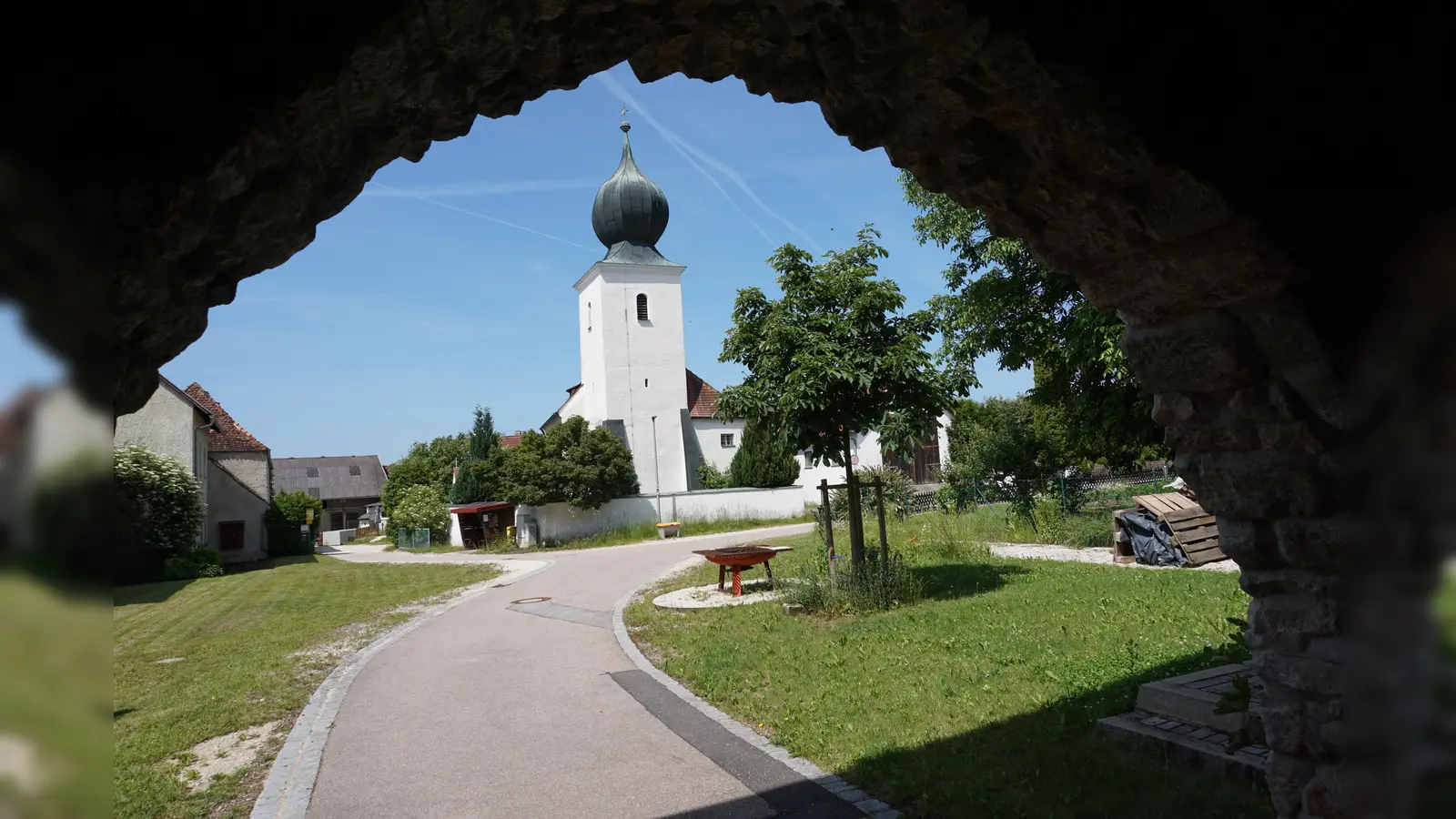 Auf dem Platz zwischen Torbogen und Kirche wird in Hirschwald am Samstag Kirchweih gefeiert (Bild: Lothar Trager)