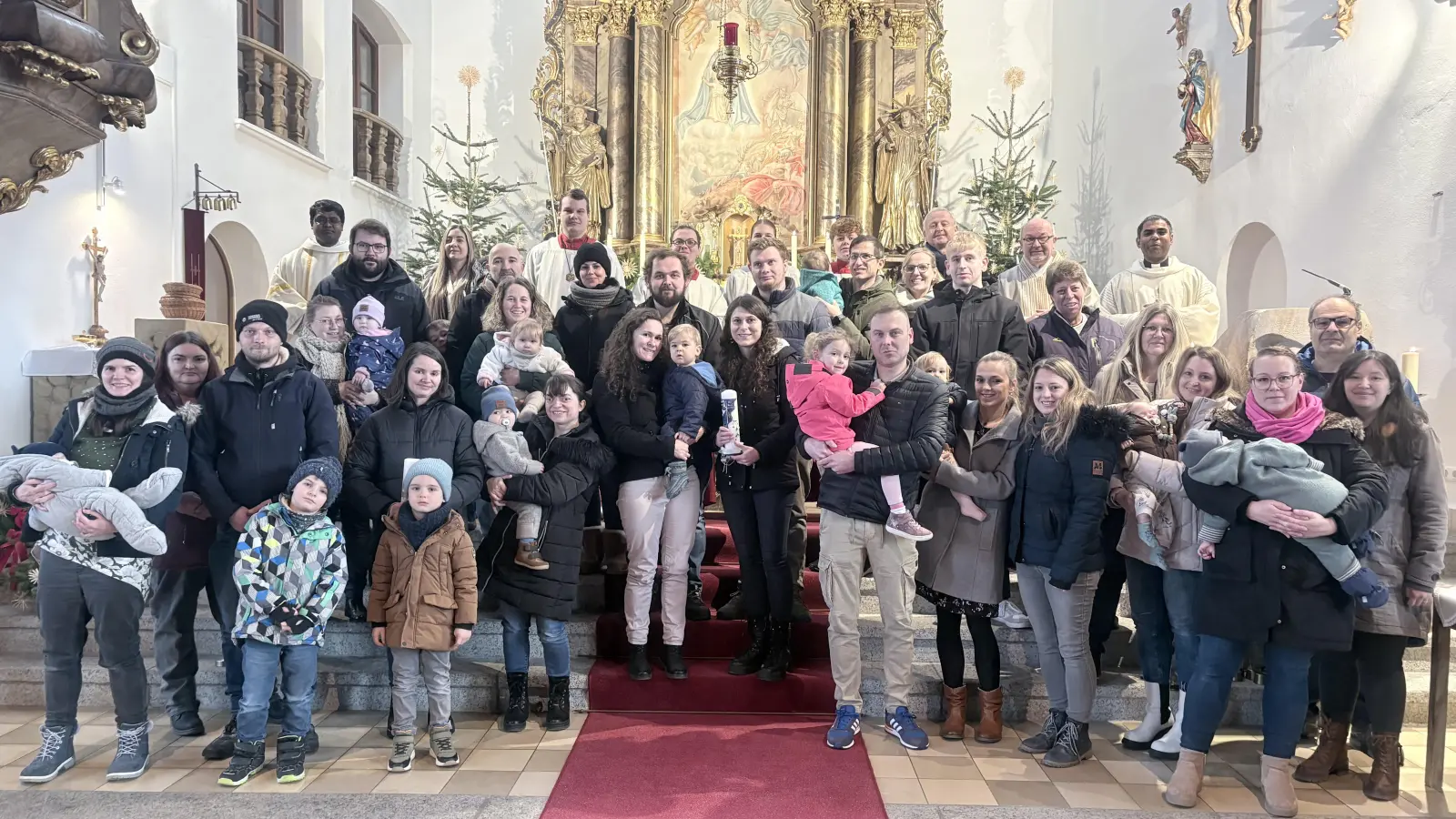 auf dem Bild sind die getauften Kinder mit ihren Eltern und Paten zu sehen, auch dabei waren Pfarrer Julius hi.re., Diakon Harald 2. hi.re., PGRSpr. Robert Bauer hi.3.re., Arbeitskreis-Kordinator Richard König re., Pfarrvikar Pater Arul hi.li. und die Ministranten hinten in der Mitte. (Bild: Alexander Hörl)
