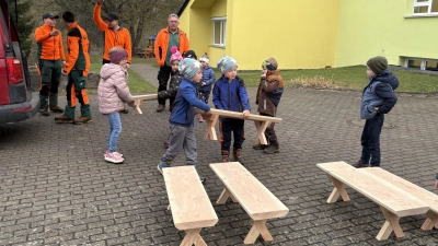 Die Kinder helfen beim Ausladen der neuen Bänke. (Bild: Nicole Schneider)