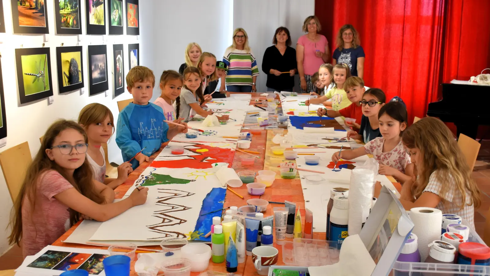 Mit großem Eifer und viel Spaß an der Sache malten 15 Buben und Mädchen beim Ferienprogramm des Kunstvereins Tirschenreuth gemeinsam zwei fünf Meter lange Leinwände aus. Auch die Betreuerinnen Petra Schicker, Petra Gehring, Kerstin Rumswinkel und Christine Michl ( v. li. vorne) hatten ihre Freude an den durchwegs sehr braven, interessierten und fleißigen Kindern.  (Bild: Ulla Britta Baumer)