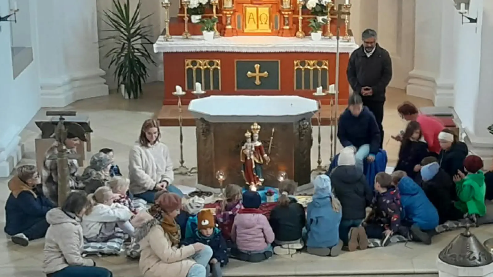 Um die Rosenkranzkönigin vor dem Volksaltar versammelten sich die Kinder und erhielten nach dem Gebet den Segen von Pater Jo Jovilla-Kurian (Bild: Sieglinde Schärtl)