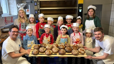 Bäckermeister Andreas Hauer (kniend links) ließ die Vorschulkinder des AWO Kinderstodl Püchersreuth, die von Lucy Preuß (stehend links) und Franziska Schuster (stehend rechts) begleitet wurden, in seine Backstube und sein Handwerk schnuppern. (Bild: Matthias Krumpholz)