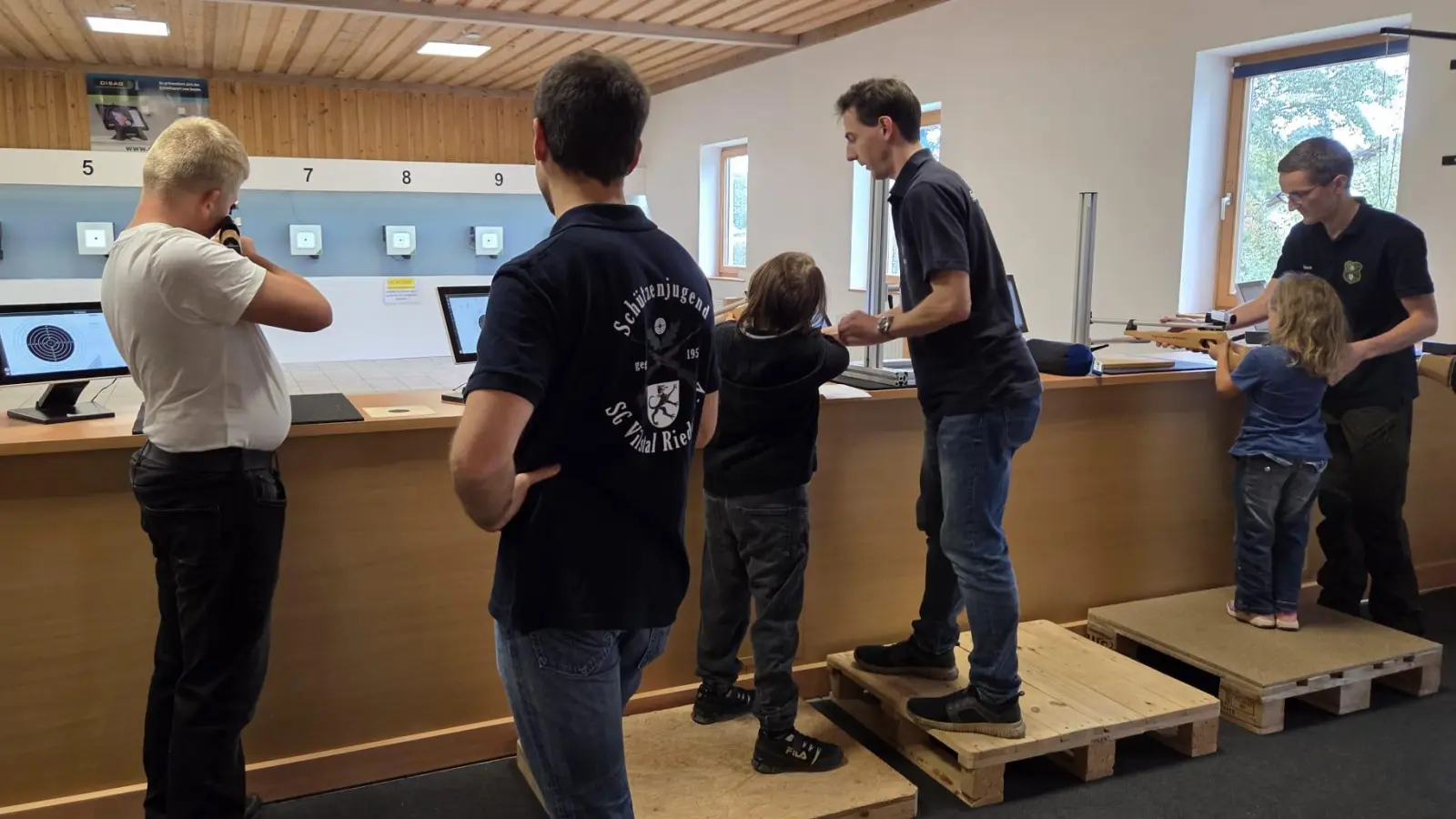 Die Jugendleiter der SG Vilstal, Thomas Rybak (4.v.l.) und Simon Wiesner (r.) weisen die Kinder beim Schnupperschießen ein. (Bild: Manfred Hiermann)