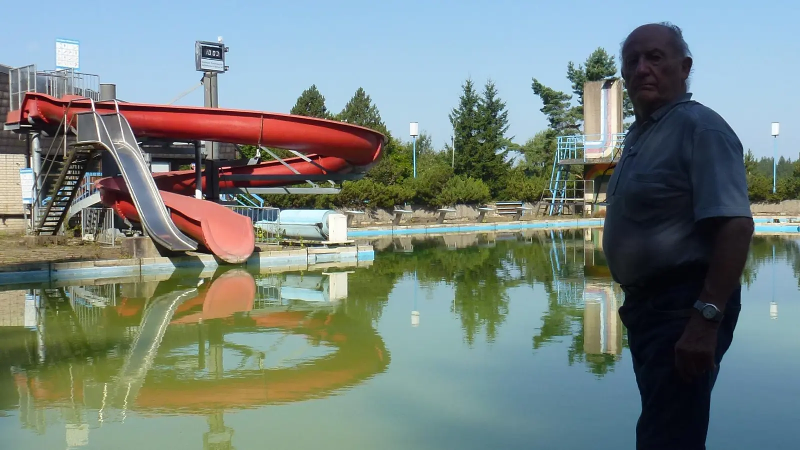 Am Beckenrand steht Schwimmmeister Siegfried Walter und schaut bedenklich über die stillgelegte Freibadeanstalt.  (Bild: Siegfried Walter)