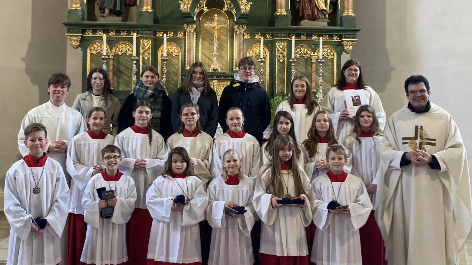 Die sechs neuen Ministranten (vordere Reihe) mit ihren Gruppenleitern (hintere Reihe; ohne liturgischem Gewand), der verabschiedeten Gruppenleiterin Vanessa (hintere Reihe, ganz rechts), weiteren Ministranten, Pfarrer Wolfgang Dietz (vordere Reihe, ganz rechts) und Gemeindereferent Christian Glaser (mittlere Reihe, ganz links). (Bild: Stephanie Zach)