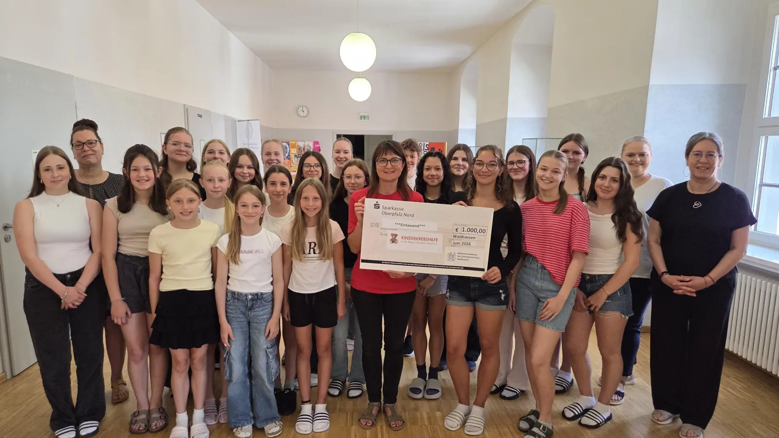 Die Klassensprecherinnen aller Klassen mit Beate Gmeiner von der Kinderkrebshilfe und Schülersprecherin Annalena Keil (Mitte - mit dem Scheck), den Verbindungslehrerinnen Astrid Krauß (2. von links) und Daniela Zahn (2. von rechts) sowie Schulleiterin Kerstin Reiter (1. von rechts) (Bild: Gerhard Skupin)