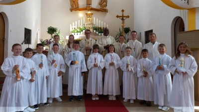 Die 11 Erstkommunionkinder freuen sich mit Pfarrer Maximilian Moosbauer, Pfarrvikar Christian Ogu und Gemeindereferent Markus Seefeld und den Ministranten über den Empfang des Sakramentes. (Bild: Johann Lobinger)