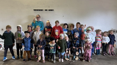 Stolz präsentieren die Kinder ihre gebastelte Baumscheiben-Deko. (Bild: Hannes Neumann )