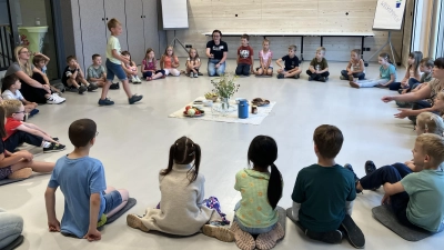 Ein großer Kreis Kinder bei der Mitmachaktion im Konferenzraum  (Bild: Manuela Hinkel)