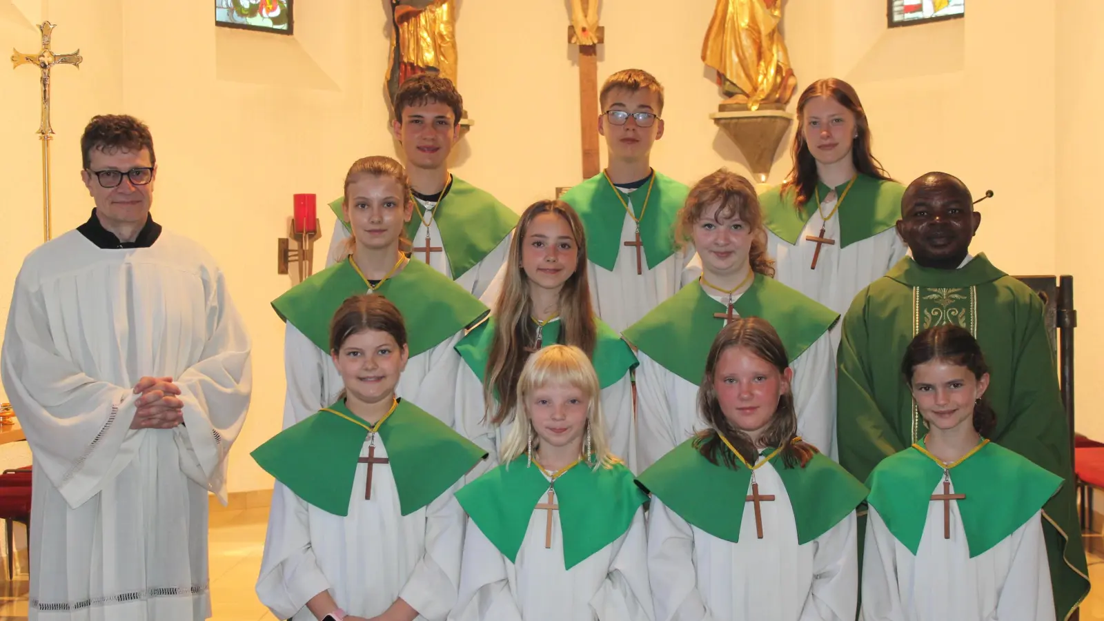 Die neuen Ministranten vorne: Laura König, Lina Dumler, Fiona Zeis und Romy Gräf. Dahinter ein Teil der Ministranten, Pastoralreferent Martin Winter und Pfarrvikar Luke Eze (Bild: Rosemarie Ernst)