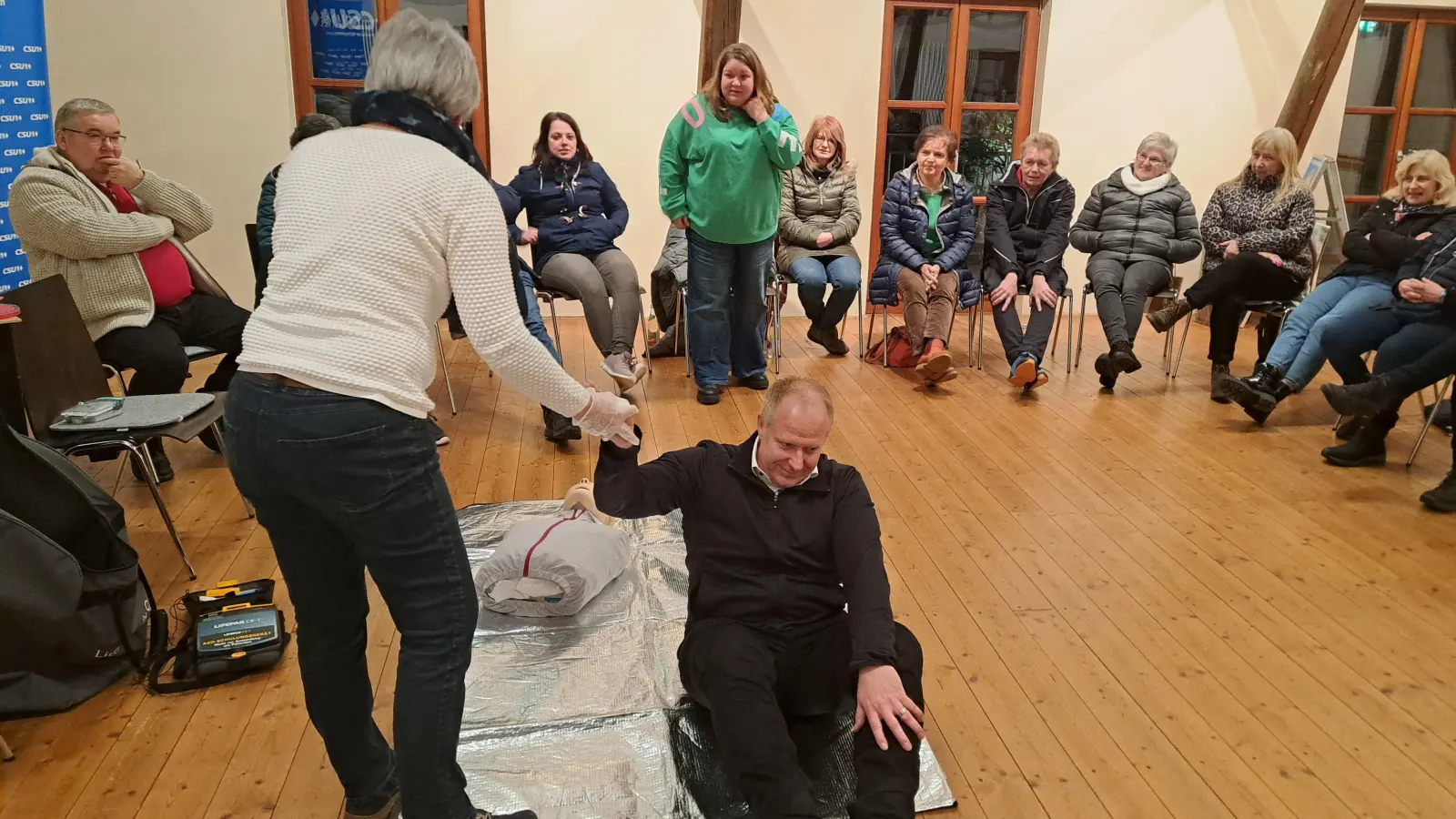 Referentin Isolde Reindl demonstrierte einen Druckverband an Bürgermeister Markus Eichenmüller. (Bild: Thomas Hottner)