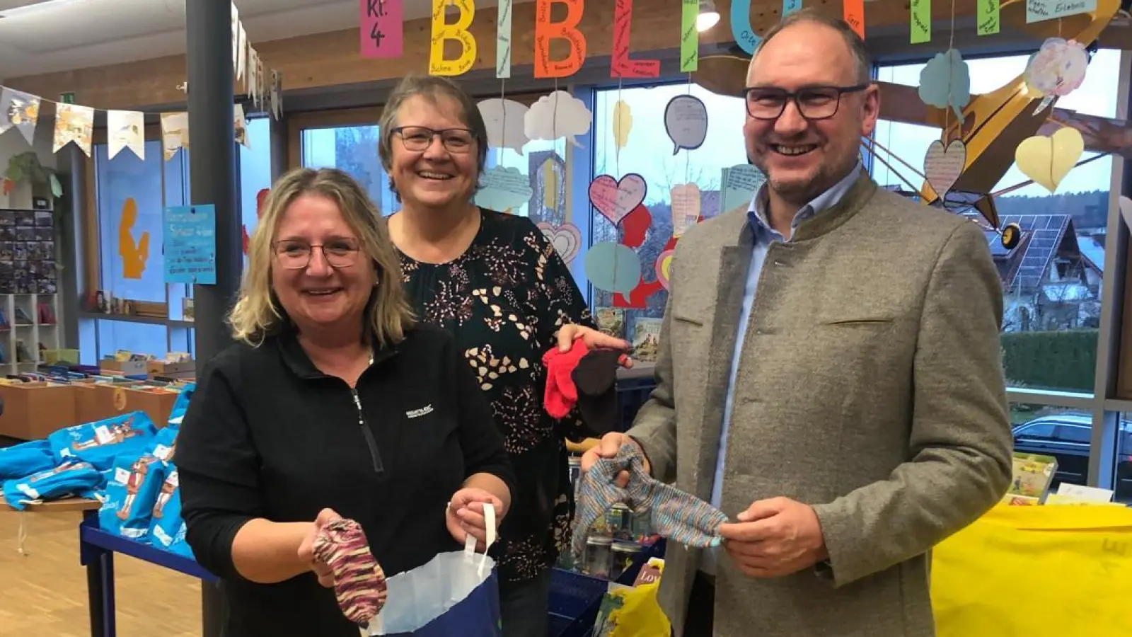 Kerstin Janner und Jutta Lippik (von links) überreichten an Bürgermeister Richard Kammerer (rechts) einen Korb voll handgestrickter Babysöckchen, die dann Familien mit Neugeborenen bekommen.  (Bild: Eva Seifried)