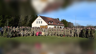 Die 97 Teilnehmer des Leistungsmarsches nach der Begrüßung am Sportgelände des FC Freihung, links und rechts eingerahmt vom Leitungs- und Funktionspersonal der RK Freihung mit Ehrenkreisvorsitzender Oberstleutnant d.R. Werner Gebhard (2. von rechts).  (Bild: Gerhard Lindthaler )