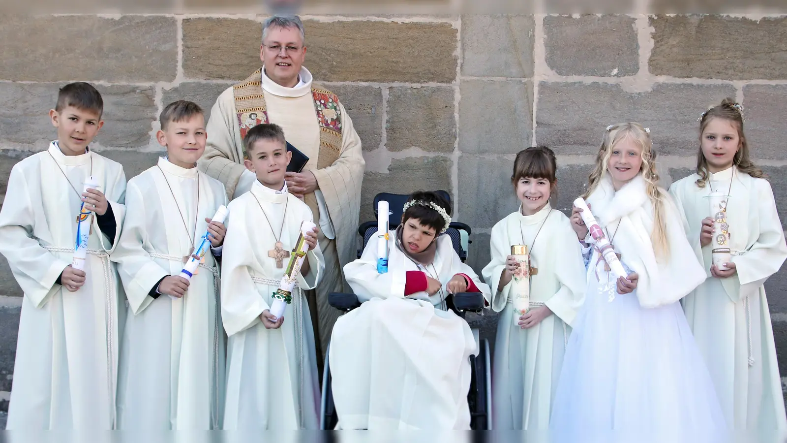 Pater Adrian Kugler mit den sieben Kommunionkindern der Pfarrei St. Luzia Schlammersdorf (Bild: Sandra Hirschke)