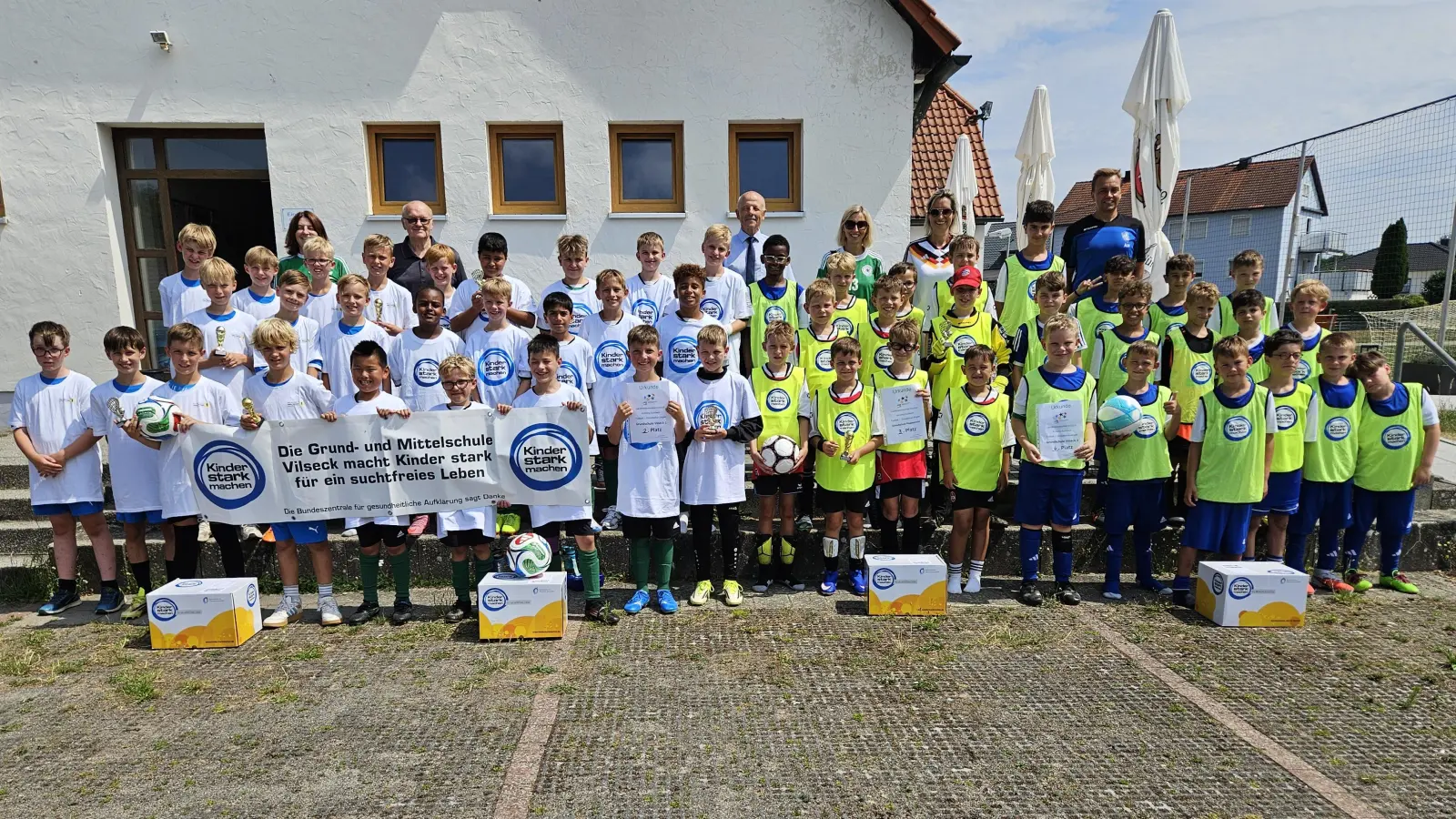 Die vier Jungen-Mannschaften nach der Grundschul-Landkreismeisterschaft auf dem Sportgelände des FV Vilseck (von links): 1. Auerbach, 2. Vilseck I, 3. Poppenricht und 4. Vilseck II mit (hinten, von links) Studienrätin Maria Danninger (Auerbach), Karl Heinz Grollmisch, Günter Simmerl, Susanne Engelhardt und Rektorin Janina Schmidt (beide Poppenricht) sowie Lehrer Alexander Merkl (Vilseck). (Bild: Christine Grollmisch)
