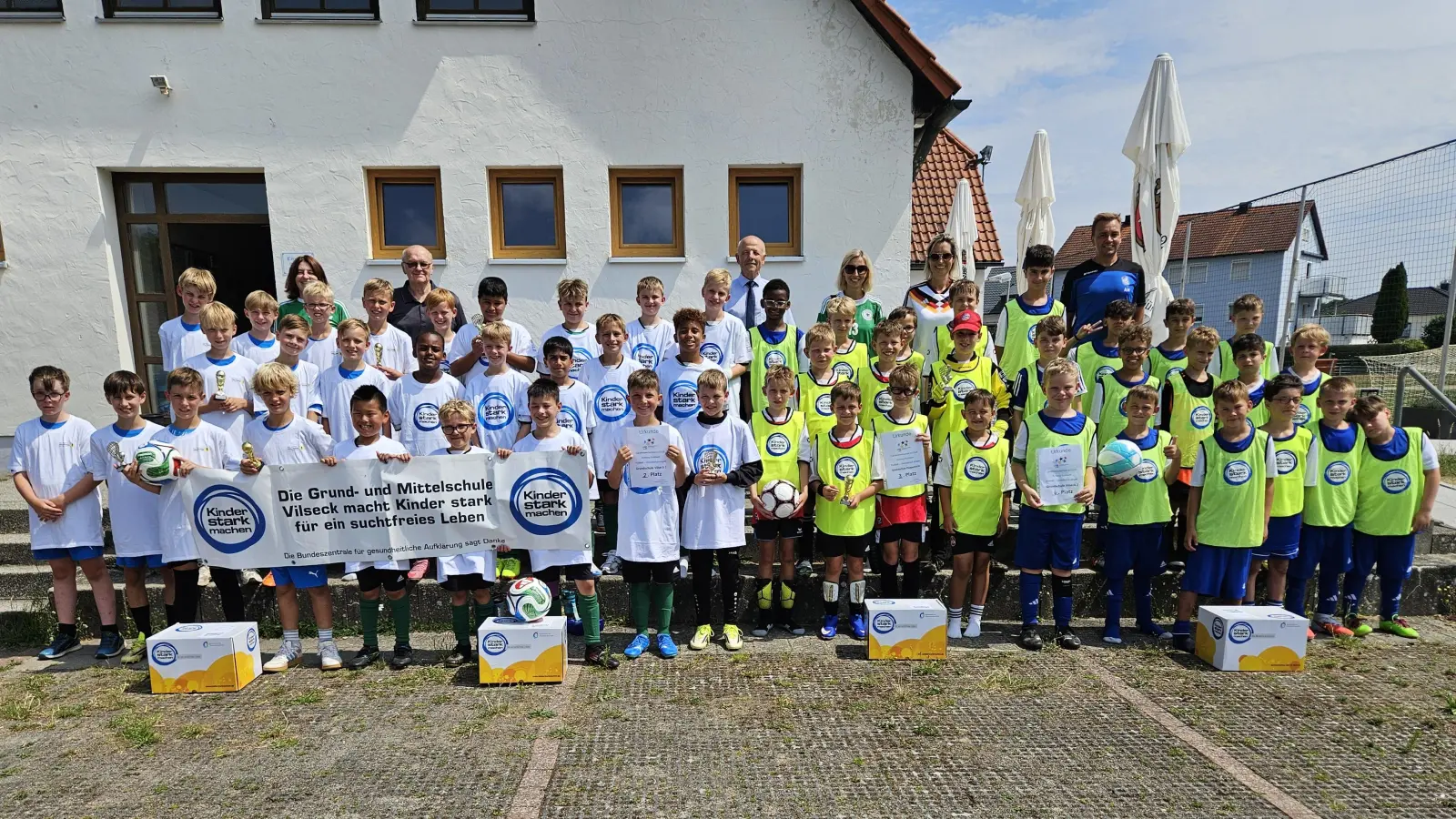 Die vier Jungen-Mannschaften nach der Grundschul-Landkreismeisterschaft auf dem Sportgelände des FV Vilseck (von links): 1. Auerbach, 2. Vilseck I, 3. Poppenricht und 4. Vilseck II mit (hinten, von links) Studienrätin Maria Danninger (Auerbach), Karl Heinz Grollmisch, Günter Simmerl, Susanne Engelhardt und Rektorin Janina Schmidt (beide Poppenricht) sowie Lehrer Alexander Merkl (Vilseck). (Bild: Christine Grollmisch)
