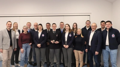 Der geehrte Stephan Bergler (8.v.l.) mit Kreiswasserwachtchef Michael Schmid (5.v.l.), Ortsgruppenleiter Jens Günther (7.v.l.) und den Ehrengästen und Vorstandsmitgliedern. (Bild: Michael Rabenhofer)