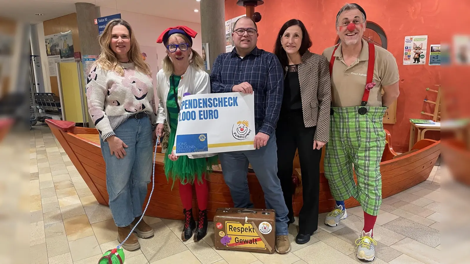 Mitglieder des Lionsclubs „Goldene Straße“ um Sekretär Alexander Kießlich (Mitte) überreichten 1000 Euro an die Klinikclowns Dr. Trudi Eierfleck und Prof. Fritz‘l Fußtaps. (Bild: Friedrich Peterhans, Klinken Nordoberpfalz)