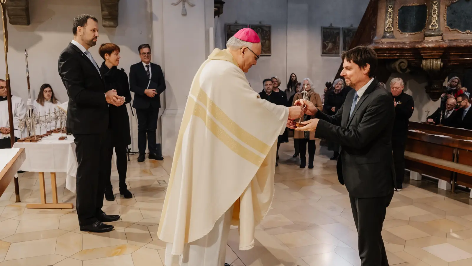 Nach dem Segensgebet überreicht Bischof Dr. Rudolf Voderholzer den neuen Katechisten ein Kreuz (rechts Stefan Hüttl). (Bild: Vanessa Goerke)