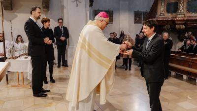 Nach dem Segensgebet überreicht Bischof Dr. Rudolf Voderholzer den neuen Katechisten ein Kreuz (rechts Stefan Hüttl). (Bild: Vanessa Goerke)