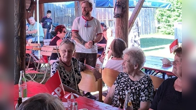 SPD-Vorsitzender Johannes Ambos (stehend) freute sich bei seiner Begrüßung über die vielen Gäste im Garten des Bikerstüberls Schwab. (Bild: Waltraud Lobenhofer)