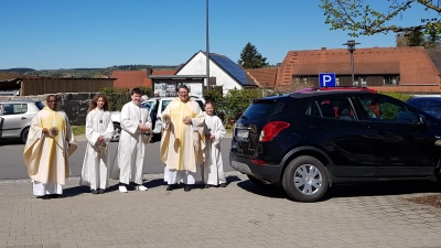 Pfarrer Udo Klösel (rechts) und Pfarrvikar Basil Bazir Ngwega schritten durch die Reihen der Fahrzeuge am Kirchplatz und segneten sie mit Weihwasser. (Bild: Peter Garreiss)