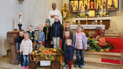 Pater Antony mit einigen Grundschulkindern und ihrem selbst gestalteten Erntedankwagen (Bild: Alexandra Kaßeckert)