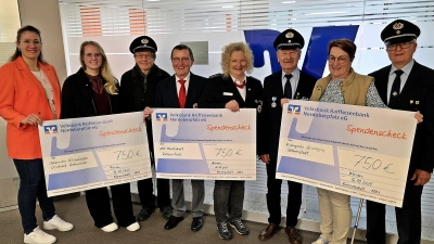 Schülerinnen der 6. Klassen überreichen zwei symbolische Spendenschecks – für strahlende Gesichter auf beiden Seiten. (4. von links Peter Wasel, 5. von links Verena Urban und die Mädchen mit den meisten geschwommenen Bahnen.  (Bild: Martina Brunner)