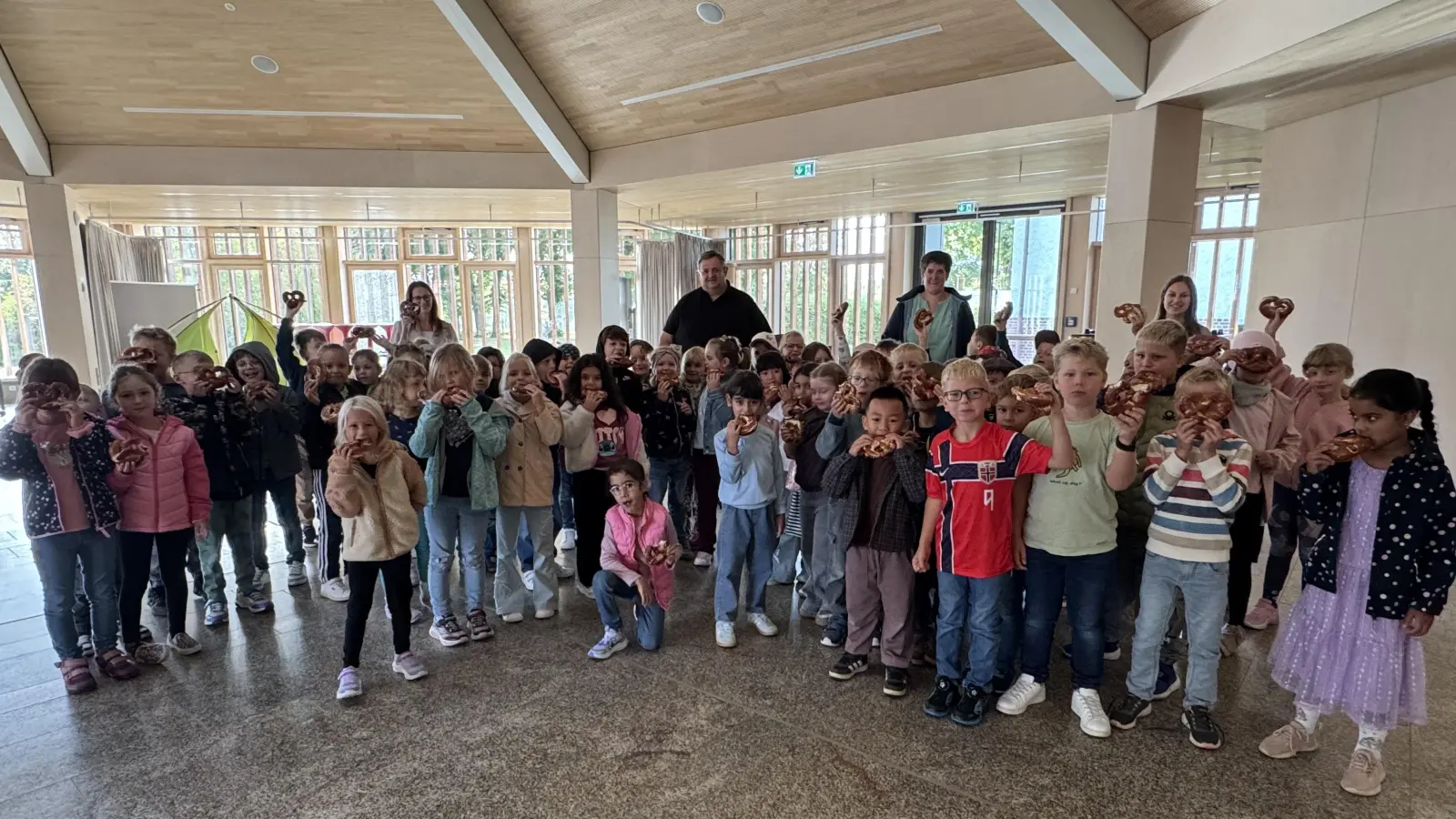 Die Schulanfänger freuen sich gemeinsam mit Fördervereinsvorsitzenden Helmut Zeitler und den drei Klassenleiterinnen über die Brezenspende. (Bild: Karin Gleißner )