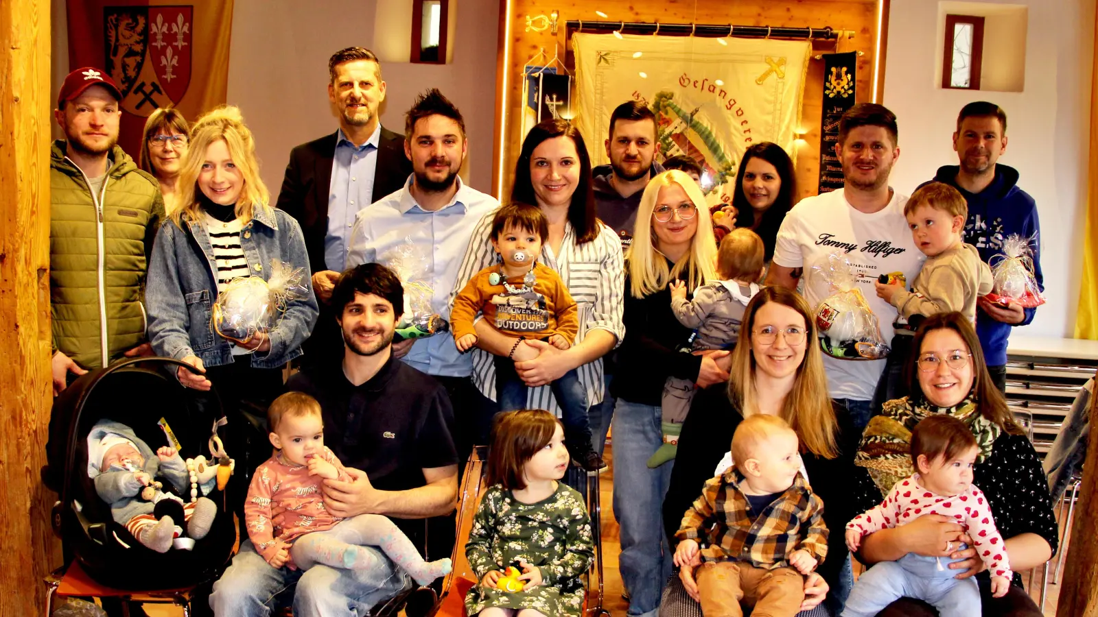 Die 2024 Neugeborenen, ihre Eltern und Geschwister fanden sich auf Einladung der Gemeinde Etzelwang zu einer Begrüßungsrunde mit Bürgermeister Roman Berr (hinten Dritter von links) und Verwaltungsangestellten Birgit Schramm (hinten Zweite von links) im Gemeindestadl ein.  (Bild: Leonhard Ehras)