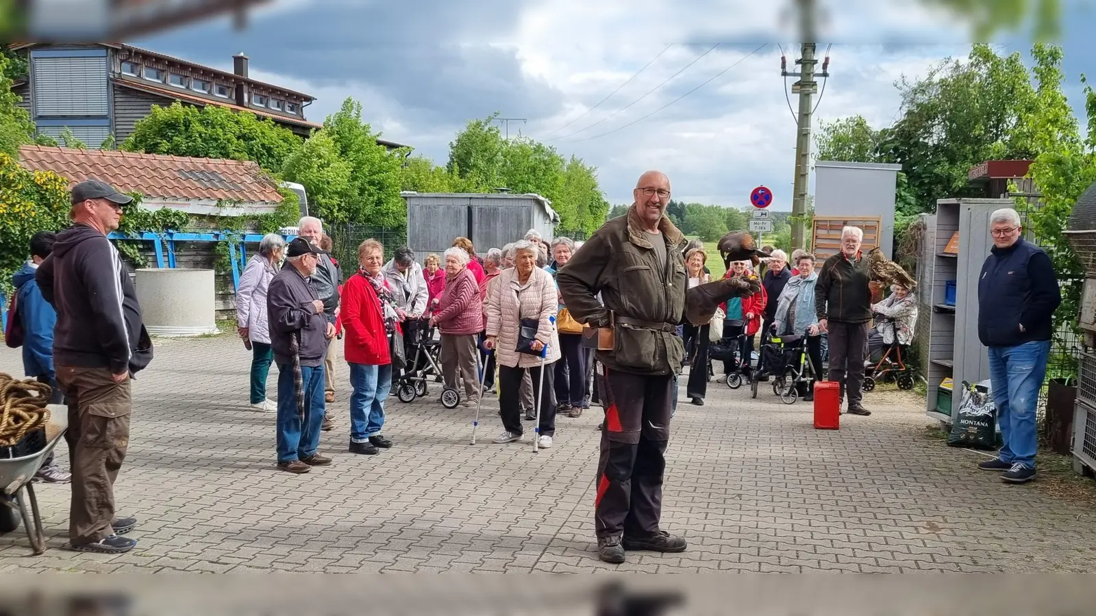 Aufmerksam verfolgten die Seniorinnen und Senioren die Flugvorführung von Hans Weiß (vorne) mit dem Wespenbussard „Lisl“. Nicht ängstliche Teilnehmer wagten es, den Uhu Klaus zu streicheln. (Bild: Rudi Wild)
