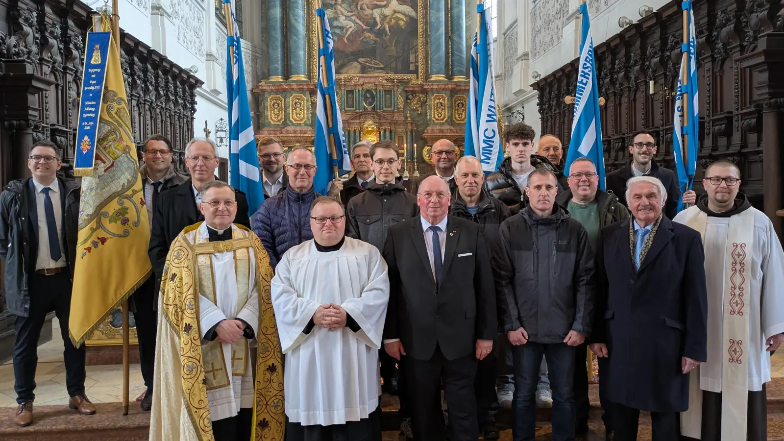 Die Neuaufnahmen des MMC in 2026: (1.Reihe von links): Zentralpräses Markus Brunner, Praktikant Christoph Diehl (St. Elisabeth Weiden), Präfekt Michael Koller, Jürgen Pröm (Freihung), Richard Glombitza (Amberg St. Georg), Vizepräses Pater Seraphin Bartosz Broniowski OFM, (2.Reihe von links): Anton Weber (Hohenburg), Thorsten Waldmann (Amberg St. Georg), Jonas Hammer (Kümmersbruck), Alexander Bachmann (Amberg St. Georg), Jakob Pröm (Freihung) und Jakob Echinger (Amberg St. Georg); dahinter die Fahnen- u. Bannerabordnungen. (Bild: Michael Koller jun.)