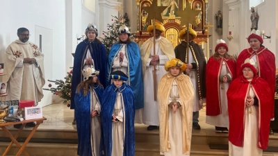 Pater Jo Jovial Kurian (links) entsandte die zehn Sternsinger und dankte ihnen, dass sie sich auf dem Weg machten, um für andere Kinder zur sammeln. (Bild: Sieglinde Zitzmann)