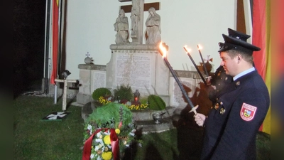 Am Kriegerdenkmal draußen vor der Kirche St. Nikolaus stand auch eine Abordnung der Feuerwehr Pittersberg bei der Kranzniederlegung durch Wehr und Bürgermeister mit Fackeln Spalier. Stille und Ruhe aus Dankbarkeit gegenüber den Toten waren eingekehrt.  (Bild: Michael Götz)