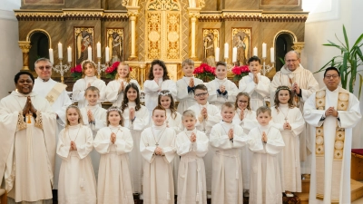 Erstkommunion in Plößberg 2025. Auf dem Bild die Kommunionkinder mit von links Pfarrvikar Edmund Onah, Diakon Egon Giehl, Pfarrer Thomas Thiermann, Pfarrer Samuel Patton. (Bild: Fotostudio Hummer)