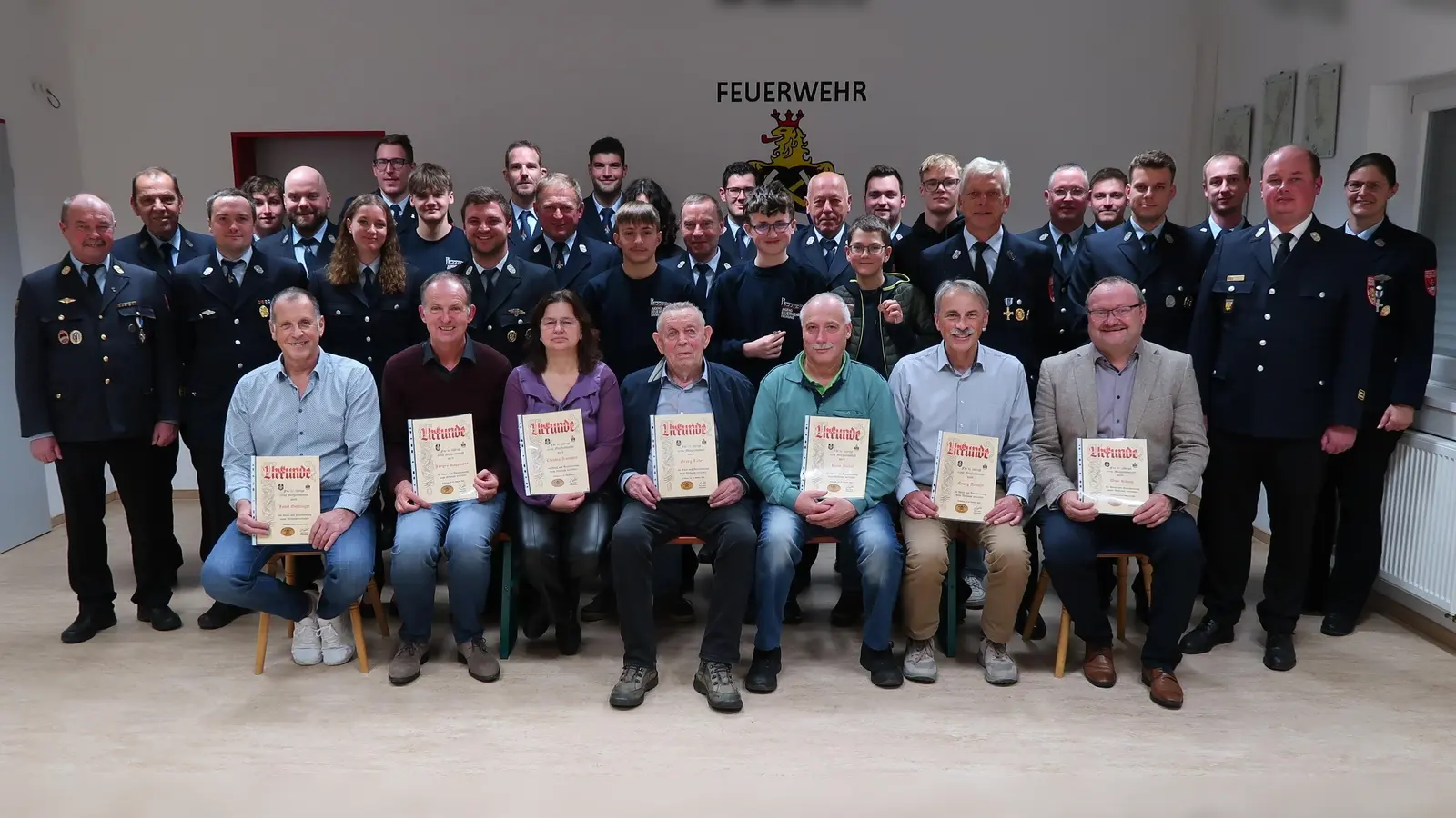 Eingerahmt von den Gratulanten stellten sich am Ende des Ehrenabends alle verdienten Kameradinnen und Kameraden zusammen. Sitzend mit Urkunde von links: Josef Göttlinger, Jürgen Koppmann, Claudia Kummer, Georg Luber, Hans Böhm, Georg Arnold und Uwe König. (Bild: Stephanie Wölfl)