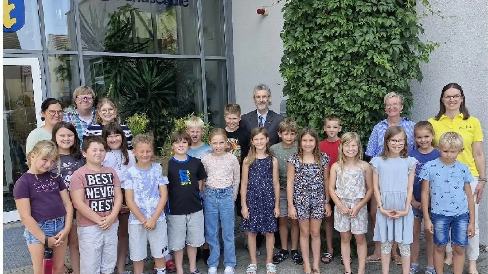 Kommunionkinder mit Klassenleiterinnen Julia Wendl-Schön, Verena Six, Rektorin Michaela Bergmann und Frau Christine Hecht (FLIKA Amberg) – und Pastoralreferent Stefan Dotzler und Pfarrer Helmut Brügel. (Bild: Reinhard Fraunholz)