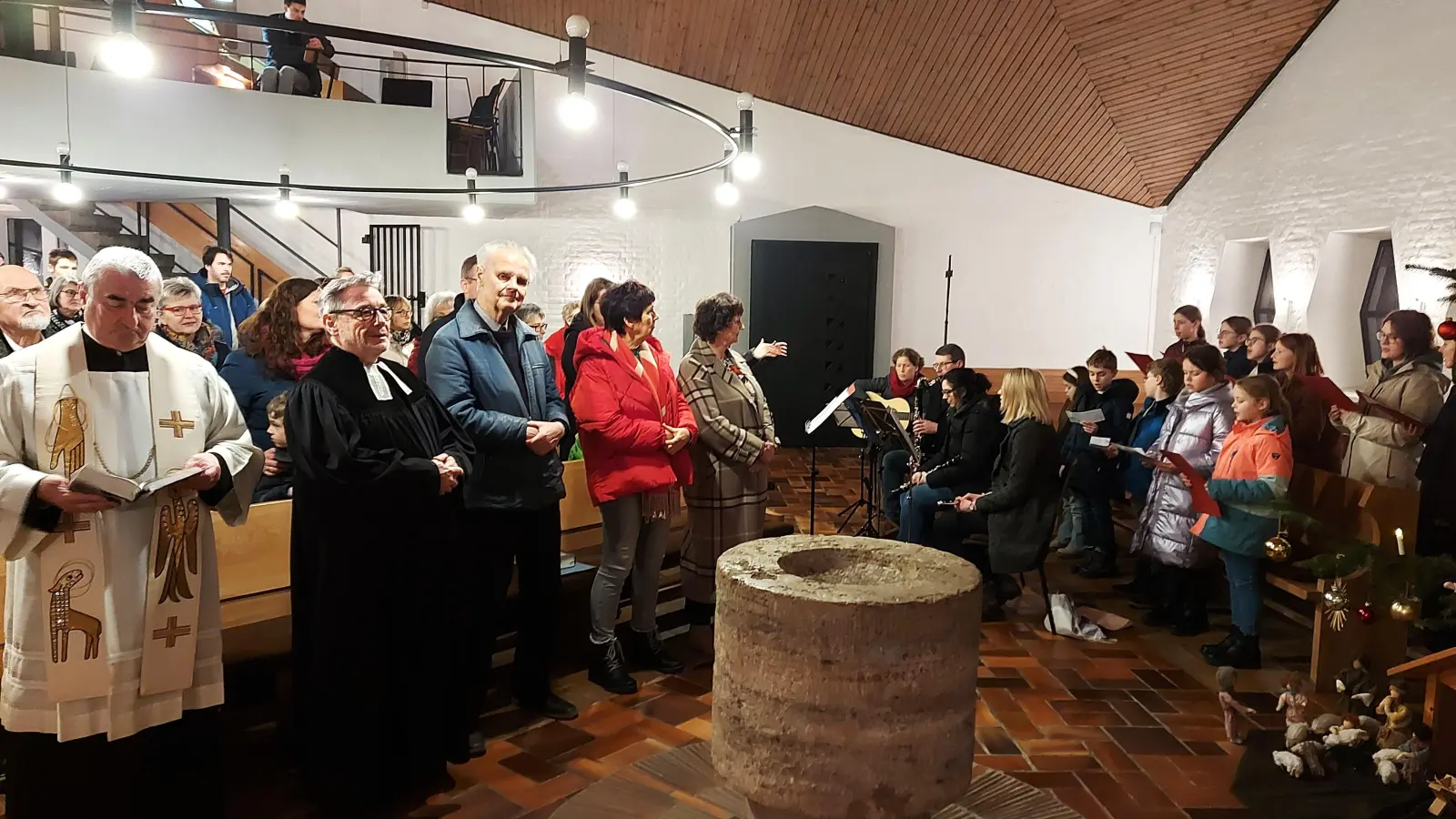 Dekan Alfons Kaufmann und Pfarrer Klaus Stolz (von links) feierten mit den katholischen und evangelischen Christen den ökumenischen Gottesdienst, der vom Chor „Pusteblume” (rechts) mitgestaltet wurde (Bild: Georg Lang)