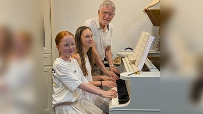 Frohgelaunt spielen Emelie Rörich (links) und Pia-Sofie Meier unter Anleitung von Luis Denz am Flügel. (Bild: Karl Wildenauer)