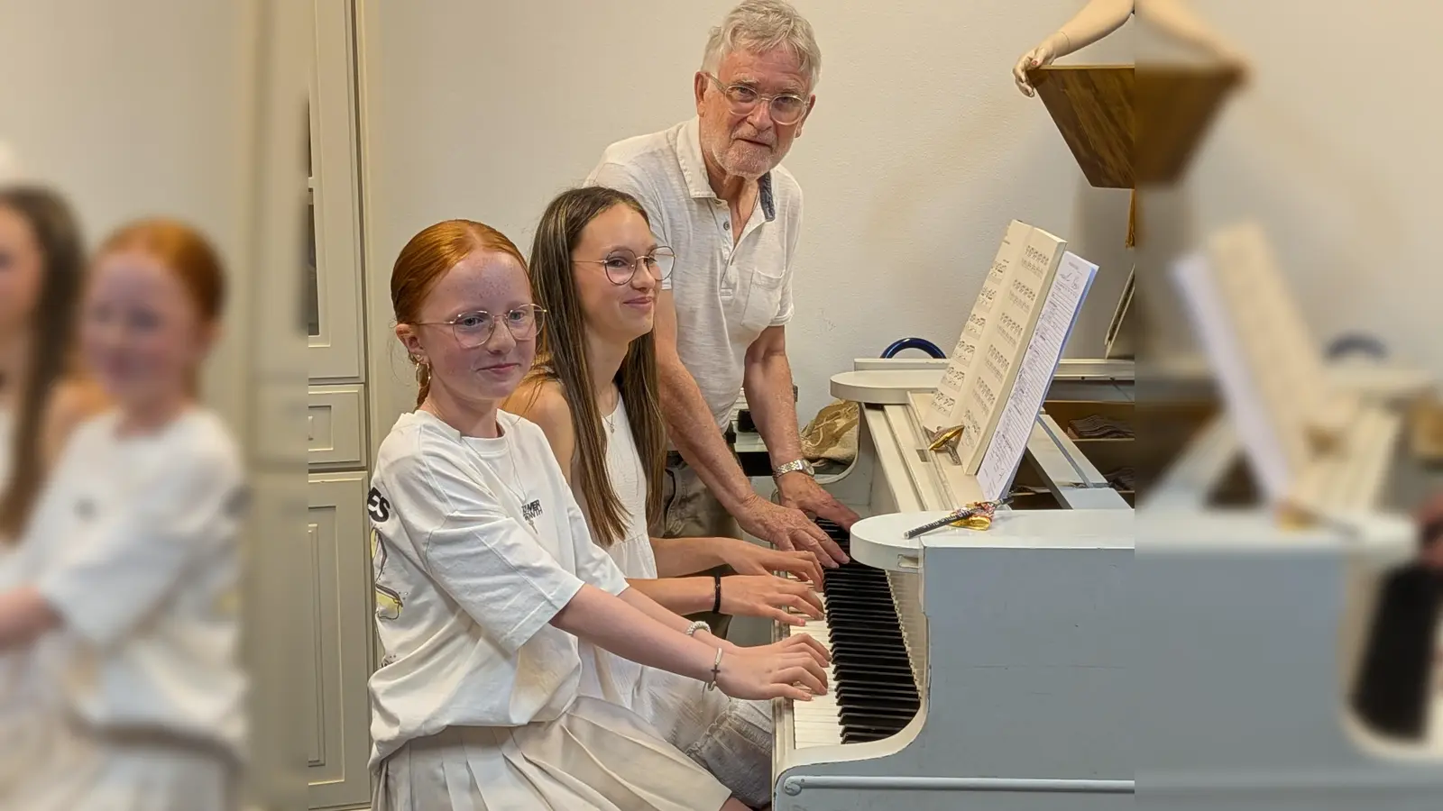 Frohgelaunt spielen Emelie Rörich (links) und Pia-Sofie Meier unter Anleitung von Luis Denz am Flügel. (Bild: Karl Wildenauer)