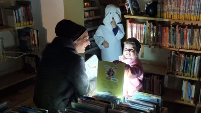 Kinder beim Suchen von Büchern mit Taschenlampe (Bild: Georg Dürr)