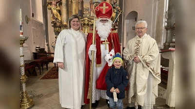 Im Erinnerungsbild (von links) Gemeindereferentin Kathrin Blödt, der Heilige vom Himmel, dann der Bub Vinzenz, der sichtlich keinerlei Angst vor dem Himmelsmann hatte und Pfarrer Josef Beer. Der Nikolaus sprach von viel Not unter den Menschen seiner Zeit, wie beispielweise den Armen und wie er ihnen in seiner Güte mit heimlichen Gaben geholfen habe. <br> (Bild: Michael Götz)