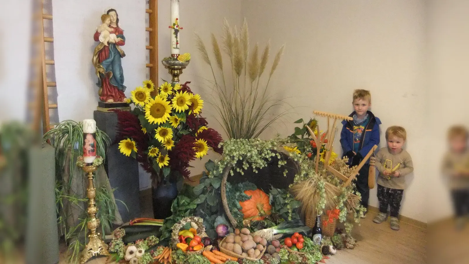Ein reichhaltiger Dankaltar mit den Früchten der Erde von 2026 lag hier beispielsweise Maria mit dem Jesuskind am Marienaltar zu Füßen. Da staunten nach dem Festgottesdienst nicht nur die zwei Buben auch viele weitere Kinder und freuten sich sichtlich sehr! (Bild: Michael Götz)