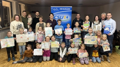Stolz präsentierten die Kinder ihre Bilder auf denen Sie ihre Wünsche und Ideen für ihr Grafenwöhr der Zukunft auf Papier brachten. 12 Motive sind im CSU-FU-JU Kalender des Jahres 2026 nun zu finden. Die Stadtratskandidaten der CSU gratulierten den jungen Künstlern.  (Bild: Julia Brunner )