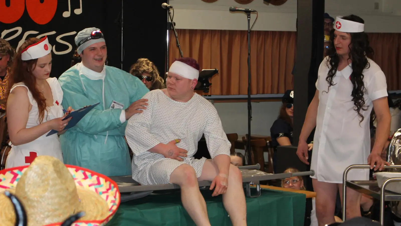 Nach dem simulierten Herzinfarkt ist Feuerwehrmann Lukas (Lukas Baumann, Zweiter von rechts) nicht amüsiert über die Aussicht, für „Doktor Elias” (Elias Schlicht), Zweiter von links) als chirurgisches Versuchskaninchen herhalten zu sollen. Als „Krankenschwestern” assistierten Lena Schecklmann (links) und Lukas Deubzer (rechts). (Bild: Bernhard Piegsa)