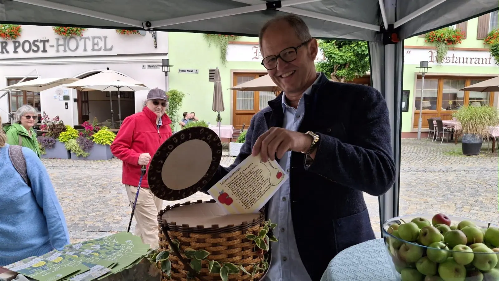 Einwurf der Teilnahmekarte beim Ratequiz „Wie viele Äpfel befinden sich im Glas?” (Bild: Karin Hiltel)