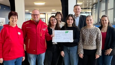 Schulleiter Jürgen Gleixner, Lehrkräfte und die SMV überreichen den symbolischen Scheck über 1.200 Euro. (Bild: Christian Eiblmeier)