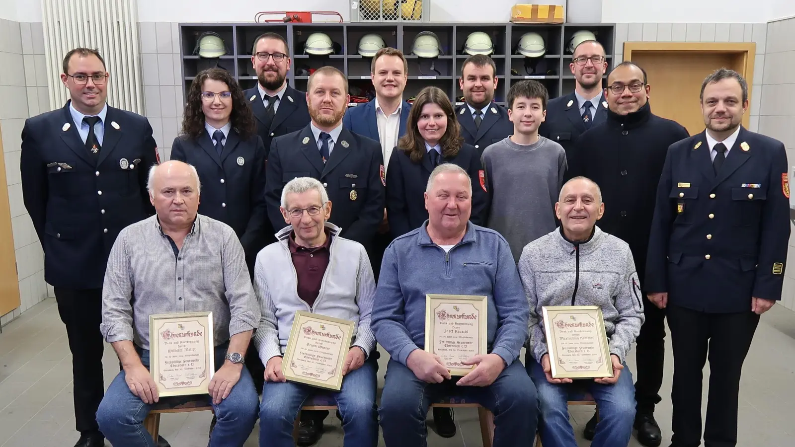 Die geehrten Kameraden der Feuerwehr Ebersbach umrahmt von den Ehrengästen<br>(Sitzend von links): Wilhelm Meiler, Erwin Winter, Josef Reuschl und Max Hammer.<br>(Stehend von links): 1. Kommandant Wolfgang Rösch, Schriftführerin Anna Reuschl,<br>Jugendwart Bernhard Lindner, 2. Kommandant Andreas Zwack, Stadtrat Jonas<br>Dittrich, ausgeschiedene Kassierin Karin Dotzler, 2. Vorsitzender Andreas Weiß,<br>Fabian Lindner, 1. Vorsitzender Manuel Lindner, Pfarrvikar Pater Jimmy Joseph<br>und Kreisbrandinspektor Michael Iberer (Bild: Christina Rabenstein)