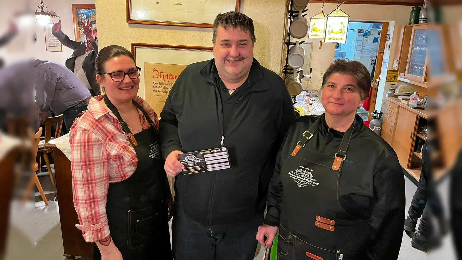 Carolin Rosner (links) und Angela Riedl (rechts), die beiden Vorsitzenden des Vereins Stammtischfreunde Plößberg e.V. freuten sich, mit Thorsten Schiener (Mitte) aus Plößberg das 100. Mitglied in ihrem Verein begrüßen zu können. Zur Belohnung gab es für ihn einen 100-Euro-Gutschein bei den Stammtischfreunden. (Bild: Jasmin Sankey)